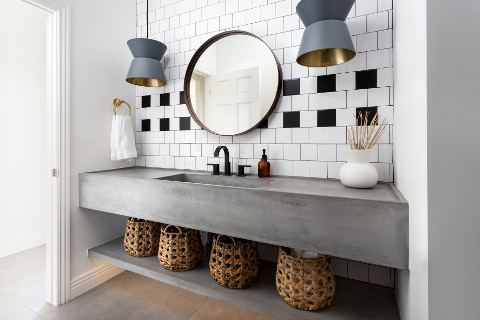 На фото: ванная комната в скандинавском стиле с серыми фасадами, черно-белой плиткой, монолитной раковиной, столешницей из бетона, серой столешницей, тумбой под одну раковину и подвесной тумбой с