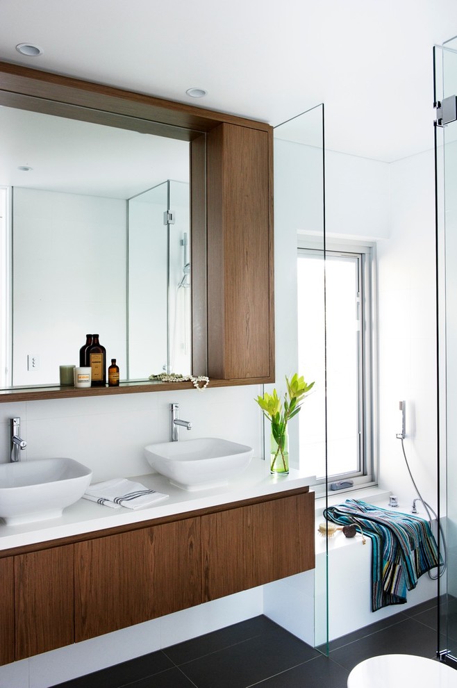Photo of a medium sized modern bathroom in Sydney with dark wood cabinets, a freestanding bath, porcelain flooring and a walk-in shower.