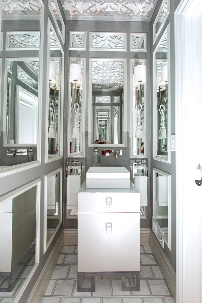 Réalisation d'une petite salle d'eau tradition avec un placard à porte plane, des portes de placard blanches, des carreaux de miroir, un mur gris, un sol en marbre, une vasque, un plan de toilette en verre et un sol gris.