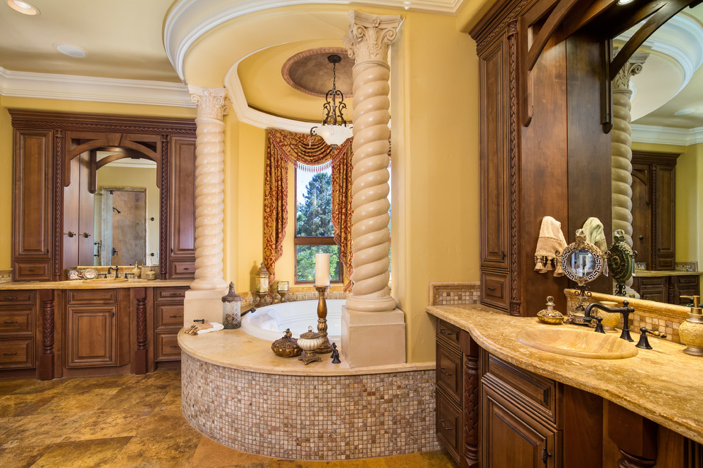 На фото: большая главная ванная комната в средиземноморском стиле с фасадами с выступающей филенкой, фасадами цвета дерева среднего тона, бежевыми стенами, накладной раковиной и гидромассажной ванной с