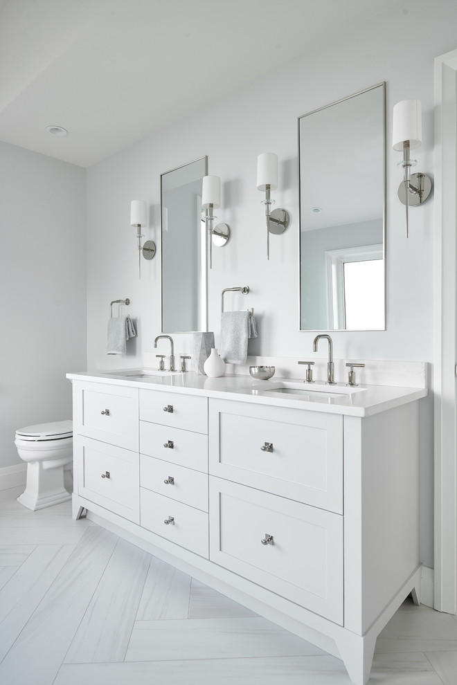 Medium sized traditional ensuite bathroom in Vancouver with freestanding cabinets, white cabinets, a freestanding bath, a one-piece toilet, grey walls, ceramic flooring, a submerged sink, engineered stone worktops, grey floors, white worktops, a corner shower, grey tiles, marble tiles and a hinged door.