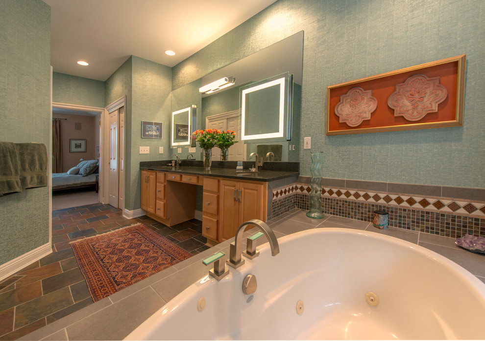 На фото: большая главная ванная комната в стиле фьюжн с фасадами с выступающей филенкой, светлыми деревянными фасадами, ванной в нише, унитазом-моноблоком, бежевой плиткой, синей плиткой, коричневой плиткой, серой плиткой, разноцветной плиткой, цементной плиткой, зелеными стенами, полом из травертина, врезной раковиной и столешницей из известняка