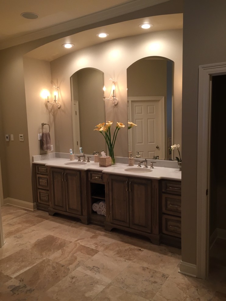 Example of a large classic master multicolored tile and stone tile porcelain tile and multicolored floor bathroom design in New Orleans with raised-panel cabinets, brown cabinets, a two-piece toilet, beige walls, a wall-mount sink, soapstone countertops, a hinged shower door and white countertops