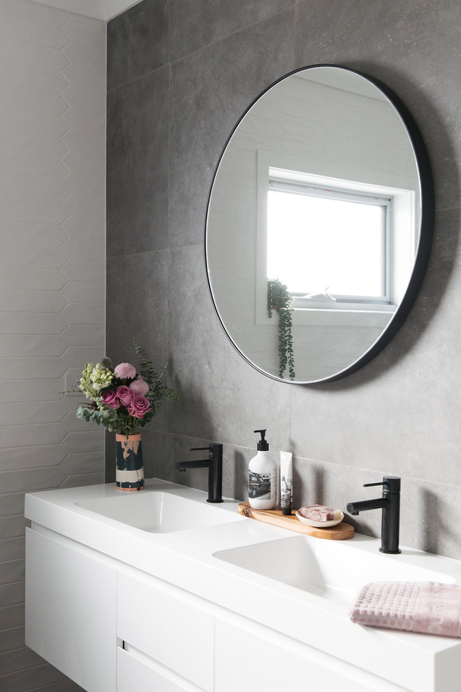 Idée de décoration pour une salle d'eau minimaliste de taille moyenne avec un placard en trompe-l'oeil, des portes de placard blanches, une baignoire posée, WC à poser, un carrelage gris, des carreaux de porcelaine, un mur gris, un sol en carrelage de porcelaine, un lavabo encastré et un sol gris.