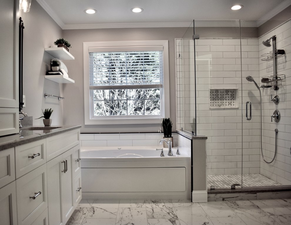 На фото: большая главная ванная комната в классическом стиле с фасадами с утопленной филенкой, белыми фасадами, ванной в нише, душем в нише, белой плиткой, плиткой кабанчик, серыми стенами, полом из керамогранита, врезной раковиной, столешницей из искусственного кварца, серым полом, душем с распашными дверями и серой столешницей