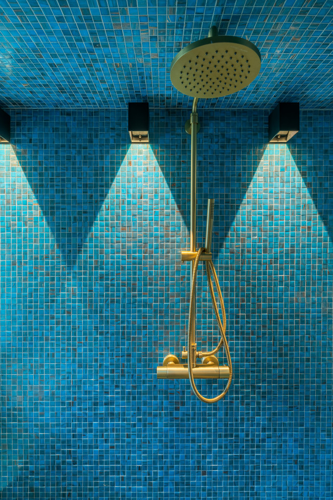 Modern inredning av ett litet bastu, med våtrum, blå kakel, mosaik, blå väggar, mosaikgolv, ett fristående handfat, blått golv och med dusch som är öppen