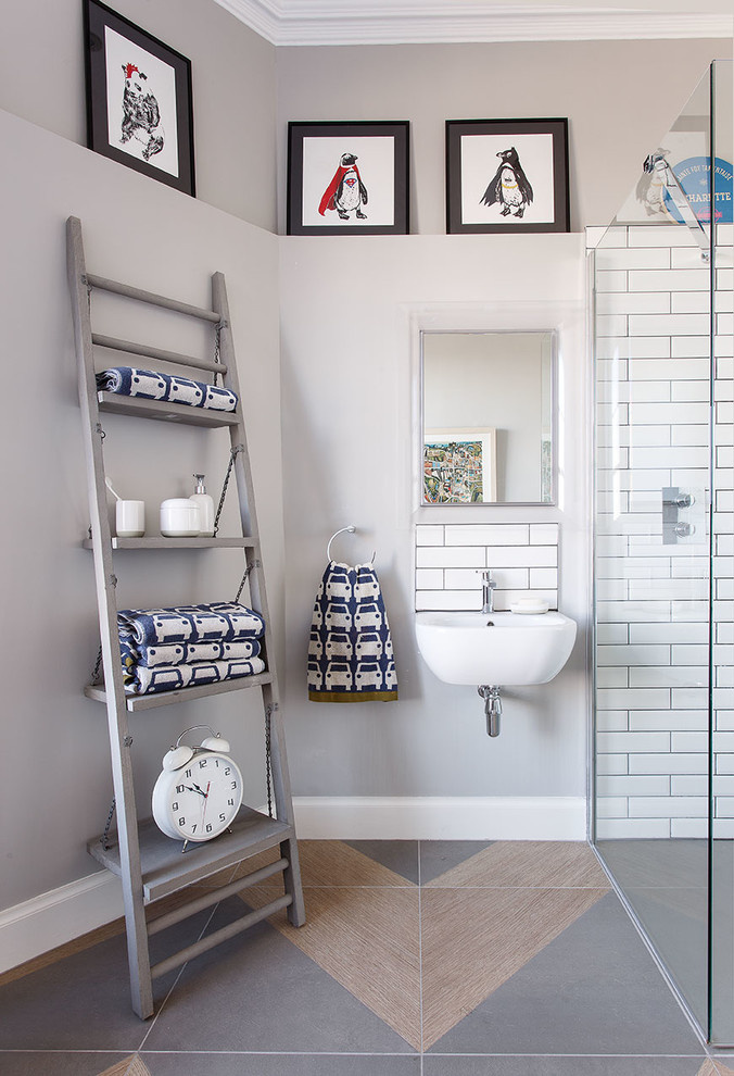Modelo de cuarto de baño actual con ducha a ras de suelo, baldosas y/o azulejos blancos, baldosas y/o azulejos de cemento, paredes grises, lavabo suspendido y suelo multicolor