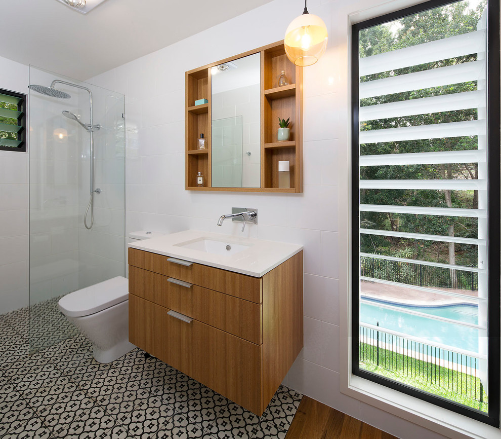 Idée de décoration pour une douche en alcôve design en bois clair avec un carrelage blanc, un sol en carrelage de céramique, un lavabo encastré, un plan de toilette en quartz modifié, un sol noir et aucune cabine.