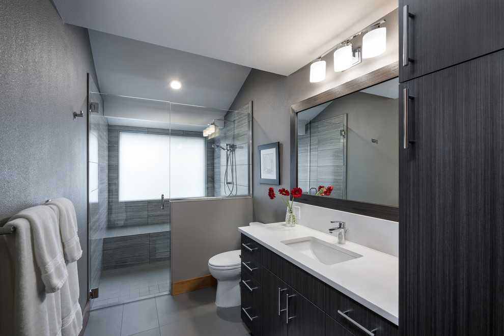 Medium sized contemporary bathroom in Portland with flat-panel cabinets, grey cabinets, a built-in shower, grey tiles, porcelain tiles, grey walls, porcelain flooring, a submerged sink, quartz worktops, grey floors, a hinged door, white worktops, a shower bench, a single sink, a floating vanity unit, a vaulted ceiling and a two-piece toilet.
