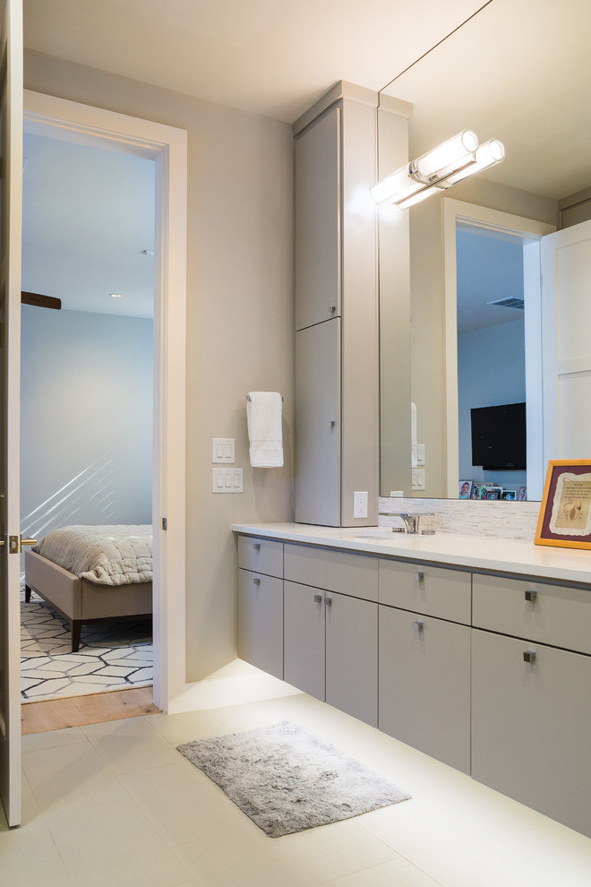 Идея дизайна: главная ванная комната в современном стиле с плоскими фасадами, серыми фасадами, серой плиткой, белой плиткой, удлиненной плиткой, полом из винила, монолитной раковиной и столешницей из искусственного камня