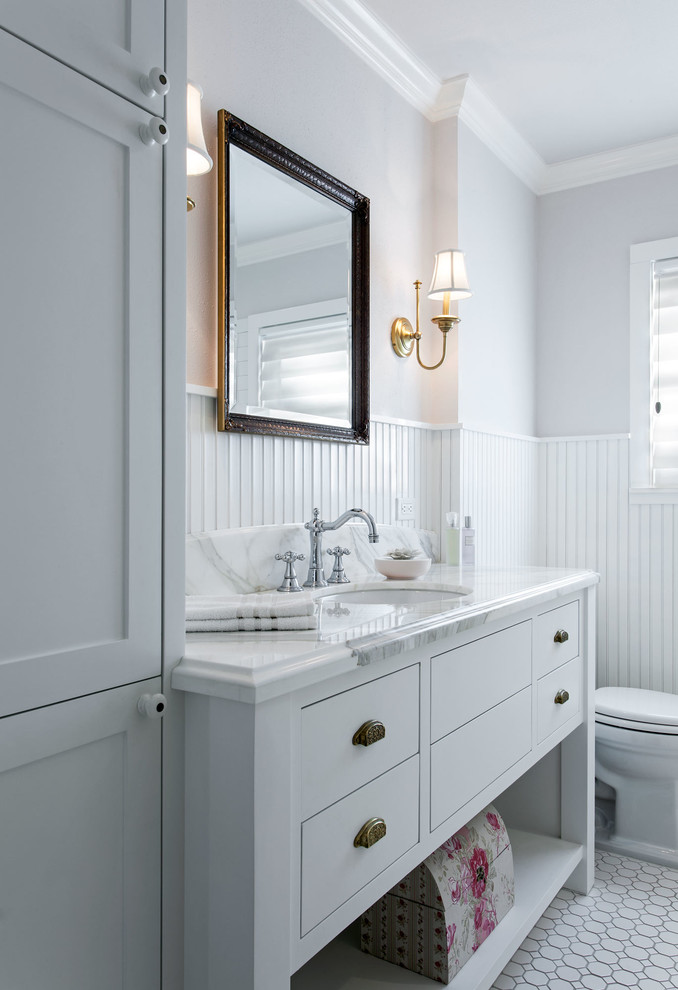 Modelo de cuarto de baño principal clásico de tamaño medio con armarios estilo shaker, puertas de armario blancas, baldosas y/o azulejos blancos, paredes blancas, lavabo bajoencimera y encimera de cuarzo compacto