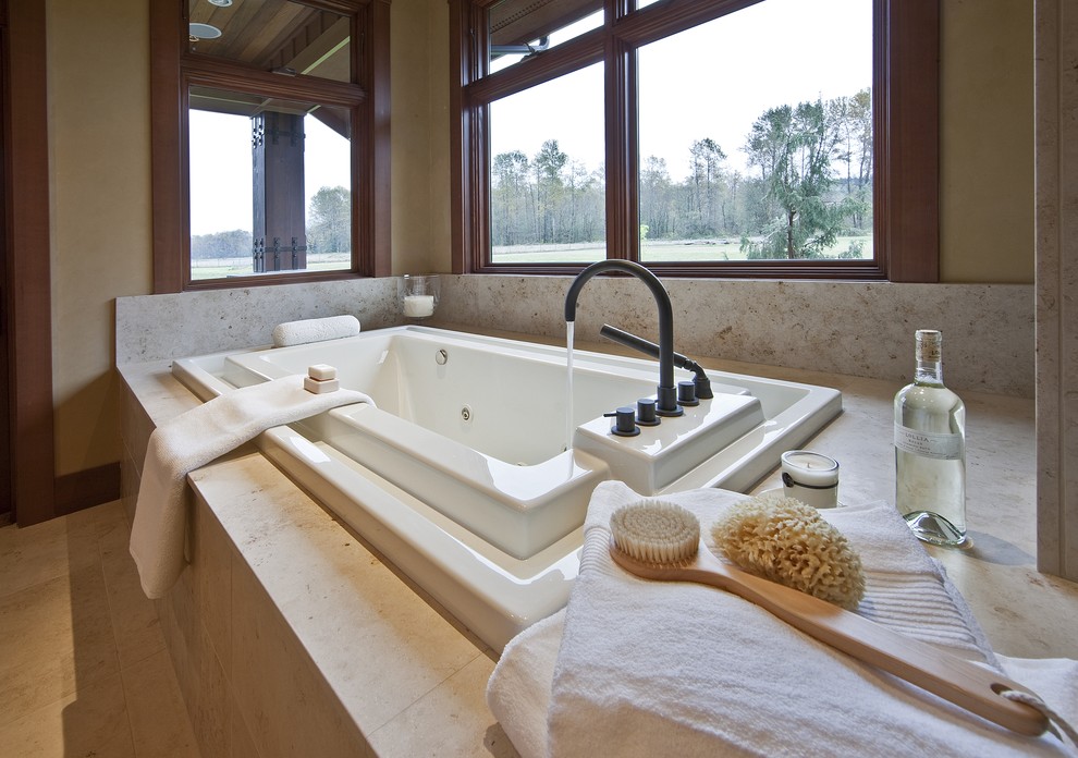 Drop-in bathtub - contemporary master beige tile and stone tile limestone floor drop-in bathtub idea in Seattle with beige walls
