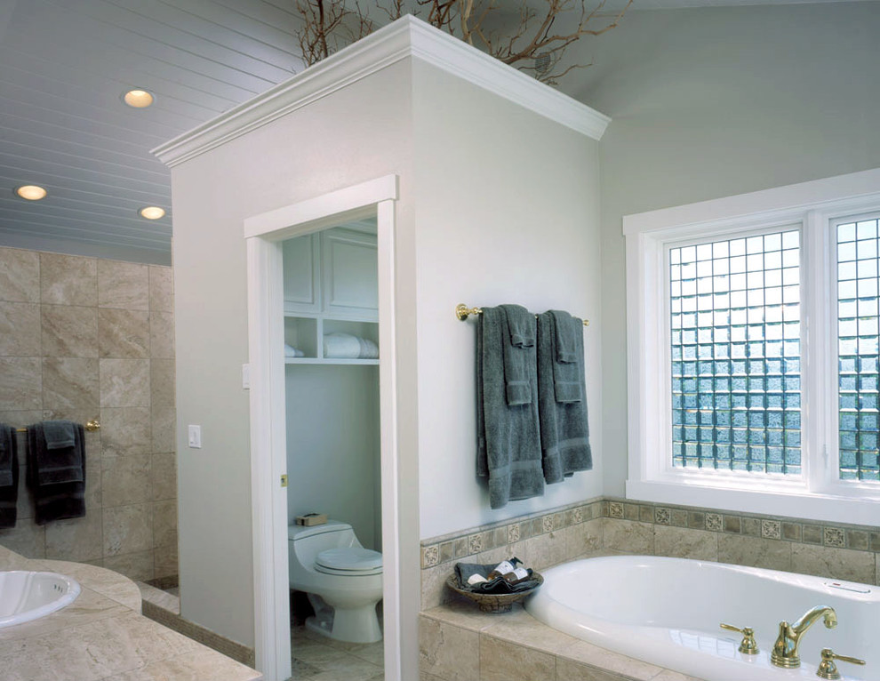 Inspiration pour une grande salle de bain principale traditionnelle avec un plan de toilette en carrelage, une baignoire posée, WC à poser, un carrelage beige, un carrelage de pierre, un mur vert et un sol en carrelage de porcelaine.