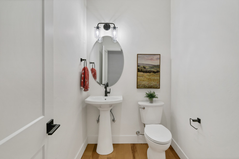 Inspiration för ett litet vintage badrum, med en toalettstol med separat cisternkåpa, vita väggar, ljust trägolv och ett piedestal handfat