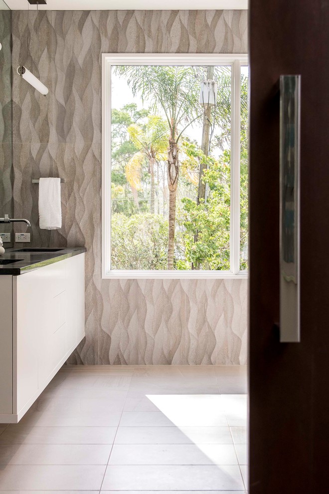 Diseño de cuarto de baño contemporáneo con puertas de armario blancas, paredes blancas, suelo de madera oscura, suelo marrón y encimeras negras
