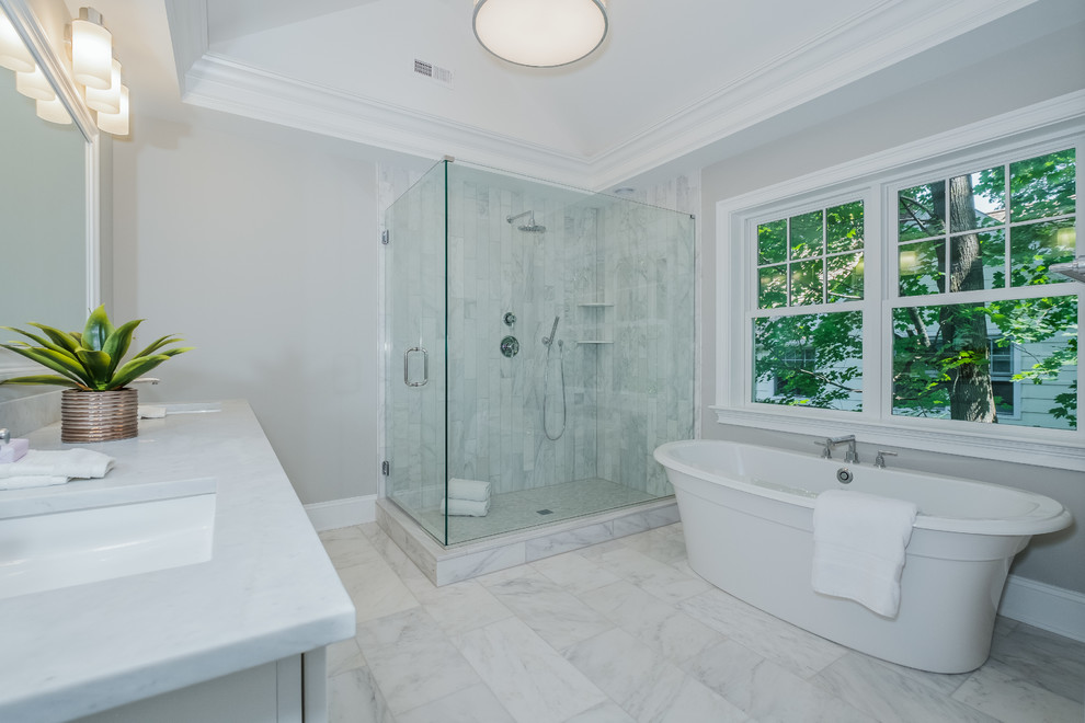 Idéer för ett mellanstort klassiskt en-suite badrum, med luckor med infälld panel, vita skåp, ett fristående badkar, en dusch i en alkov, en toalettstol med separat cisternkåpa, vit kakel, stenkakel, grå väggar, marmorgolv, ett undermonterad handfat och marmorbänkskiva