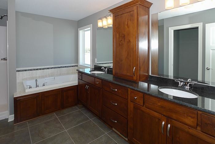 Aménagement d'une salle de bain classique en bois brun avec un lavabo encastré, un placard à porte plane et un plan de toilette en granite.