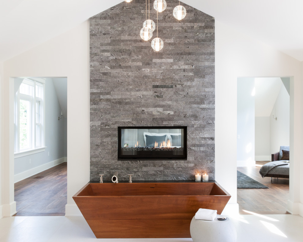 На фото: большая главная ванная комната в стиле неоклассика (современная классика) с отдельно стоящей ванной, серой плиткой, каменной плиткой, белыми стенами и полом из керамогранита с