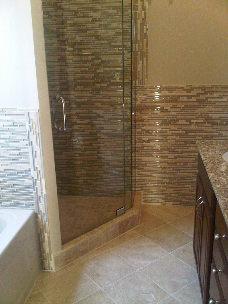 Large traditional ensuite bathroom in Chicago with recessed-panel cabinets, dark wood cabinets, a built-in bath, a corner shower, multi-coloured tiles, matchstick tiles, beige walls, a built-in sink, granite worktops, a two-piece toilet, ceramic flooring, beige floors and a hinged door.
