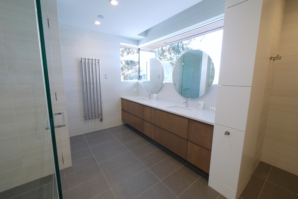 Diseño de cuarto de baño principal minimalista de tamaño medio con armarios con paneles lisos, puertas de armario de madera oscura, encimera de cuarzo compacto y baldosas y/o azulejos grises