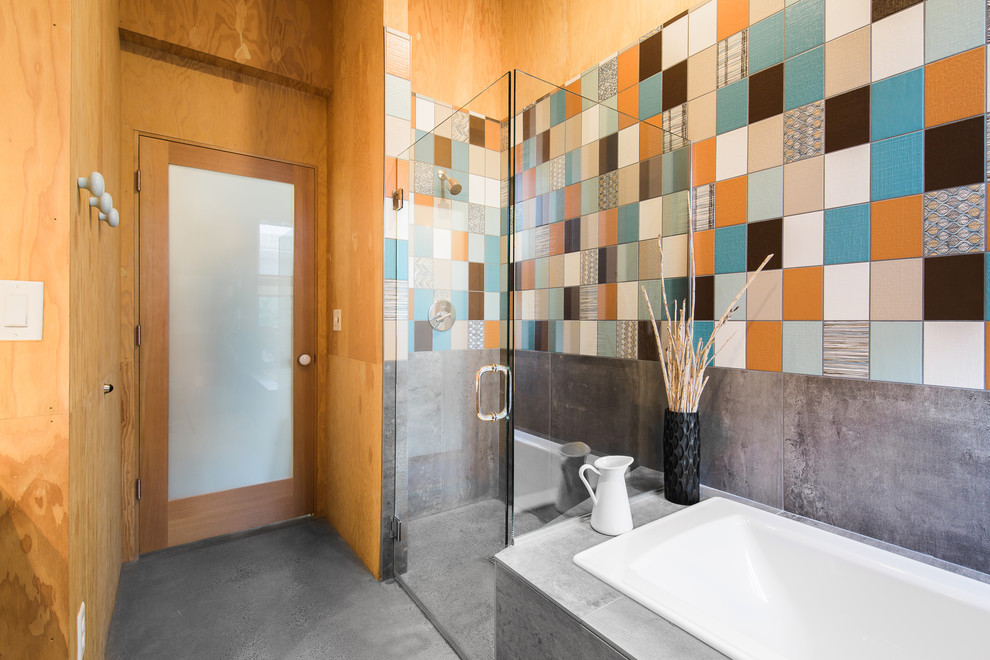 Inspiration for a contemporary multicolored tile and ceramic tile concrete floor bathroom remodel in Portland with flat-panel cabinets, gray cabinets, an integrated sink, solid surface countertops, a hinged shower door and white countertops
