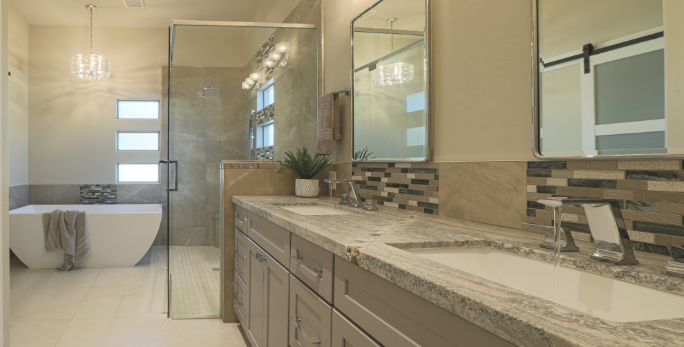 Example of a mid-sized transitional master gray tile and porcelain tile porcelain tile and beige floor bathroom design in Phoenix with shaker cabinets, gray cabinets, a one-piece toilet, beige walls, an undermount sink, granite countertops, a hinged shower door and multicolored countertops