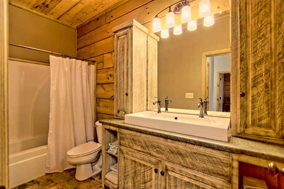 Idéer för ett litet rustikt badrum, med luckor med upphöjd panel, skåp i slitet trä, ett fristående badkar, en dusch/badkar-kombination, en toalettstol med separat cisternkåpa, grå väggar, klinkergolv i porslin, ett nedsänkt handfat, laminatbänkskiva, flerfärgat golv och dusch med duschdraperi