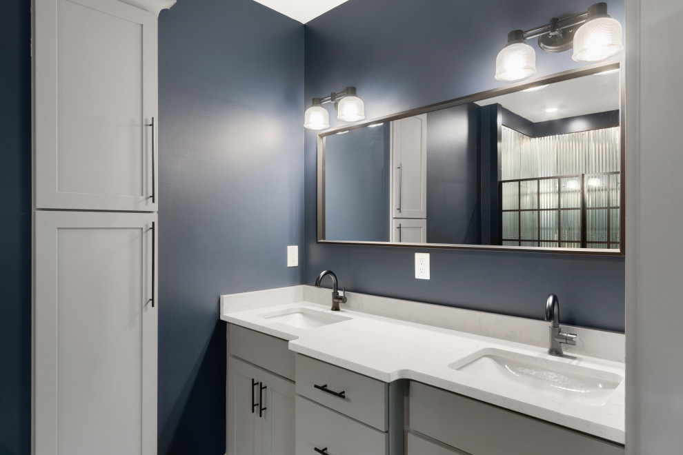 Large modern family bathroom in Milwaukee with shaker cabinets, grey cabinets, an alcove shower, a two-piece toilet, blue walls, a submerged sink, engineered stone worktops, a hinged door, white worktops, double sinks, a built in vanity unit, concrete flooring and brown floors.