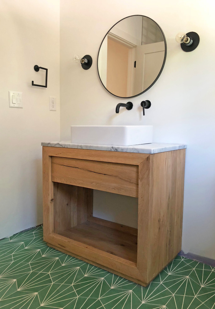 На фото: ванная комната в современном стиле с светлыми деревянными фасадами, керамогранитной плиткой, бетонным полом, настольной раковиной, мраморной столешницей и зеленым полом