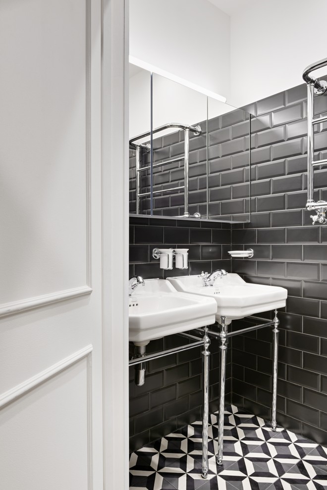 Пример оригинального дизайна: главная ванная комната в викторианском стиле с стеклянными фасадами, черными фасадами, открытым душем, черной плиткой, плиткой кабанчик, белыми стенами, полом из цементной плитки, консольной раковиной, разноцветным полом, душем с раздвижными дверями и белой столешницей
