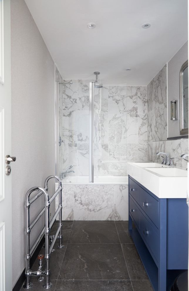 Idéer för ett litet klassiskt vit badrum för barn, med luckor med infälld panel, blå skåp, ett platsbyggt badkar, grå kakel, porslinskakel, grå väggar, klinkergolv i porslin, ett integrerad handfat, bänkskiva i akrylsten och grått golv