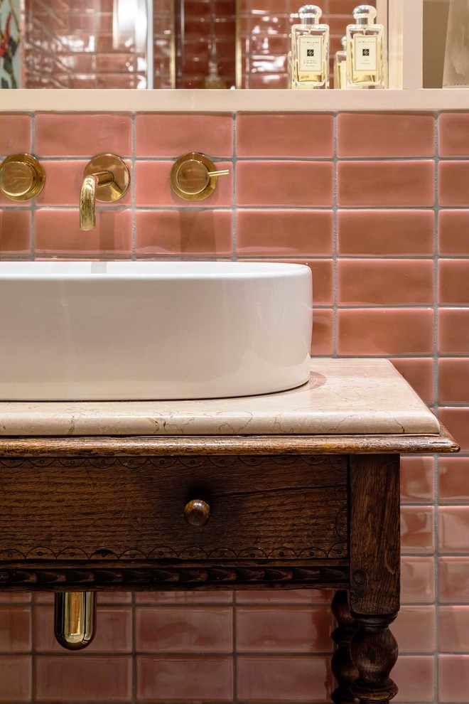 Cette image montre une salle de bain principale bohème en bois foncé de taille moyenne avec un placard en trompe-l'oeil, une douche ouverte, un carrelage rose, des carreaux de céramique, un mur multicolore, un sol en marbre, une vasque, un plan de toilette en marbre, un sol gris, une cabine de douche à porte battante et un plan de toilette blanc.