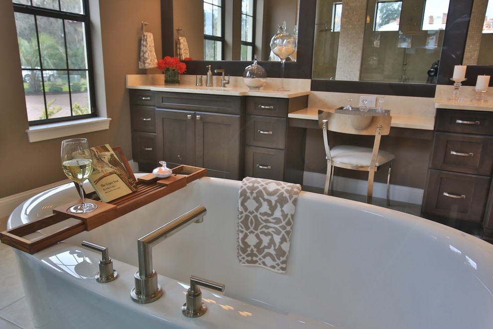 Freestanding bathtub - eclectic master ceramic tile freestanding bathtub idea in Orlando with recessed-panel cabinets, an undermount sink, dark wood cabinets, limestone countertops and brown walls