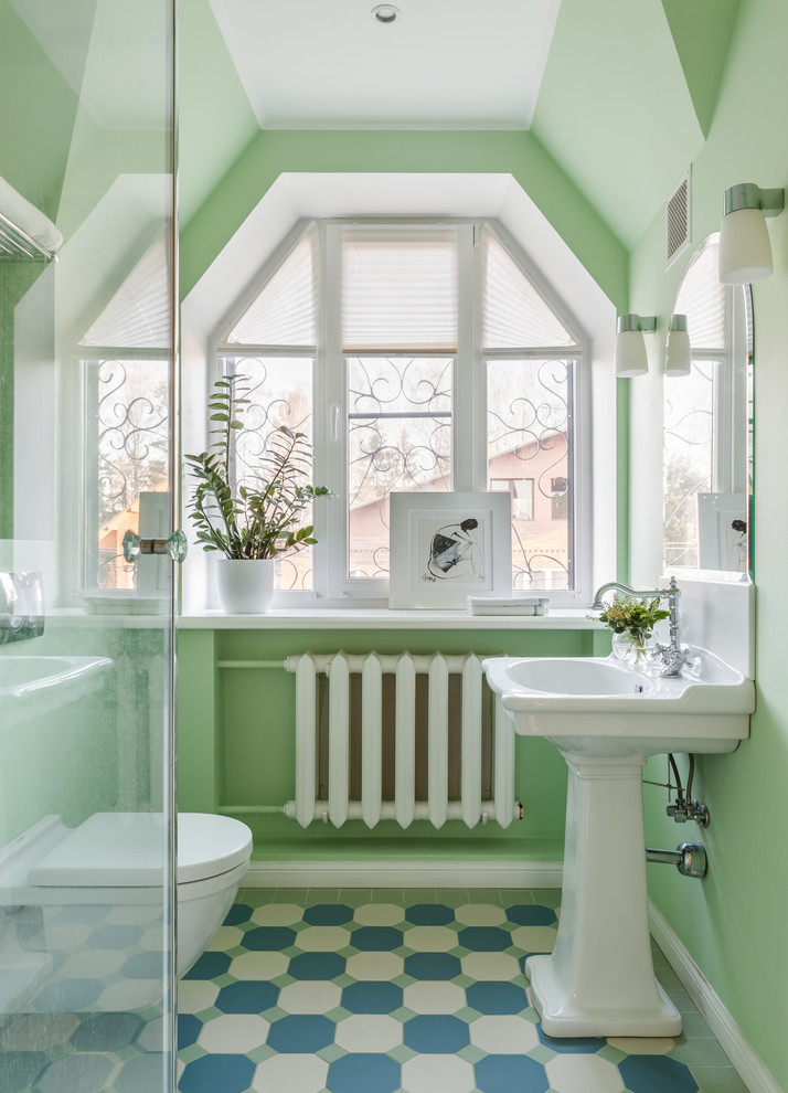 Bild på ett funkis badrum, med en toalettstol med separat cisternkåpa, gröna väggar, ett piedestal handfat och flerfärgat golv