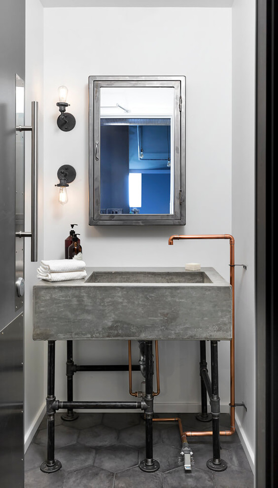 バンクーバーにあるインダストリアルスタイルのおしゃれな浴室 (磁器タイルの床、コンクリートの洗面台、白い壁、コンソール型シンク、グレーの床、グレーの洗面カウンター) の写真