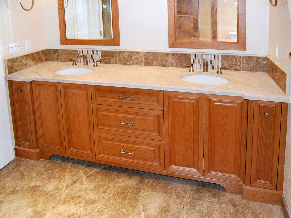 Photo of a large traditional ensuite bathroom in San Francisco with raised-panel cabinets, medium wood cabinets, beige walls, marble flooring, a submerged sink and brown floors.