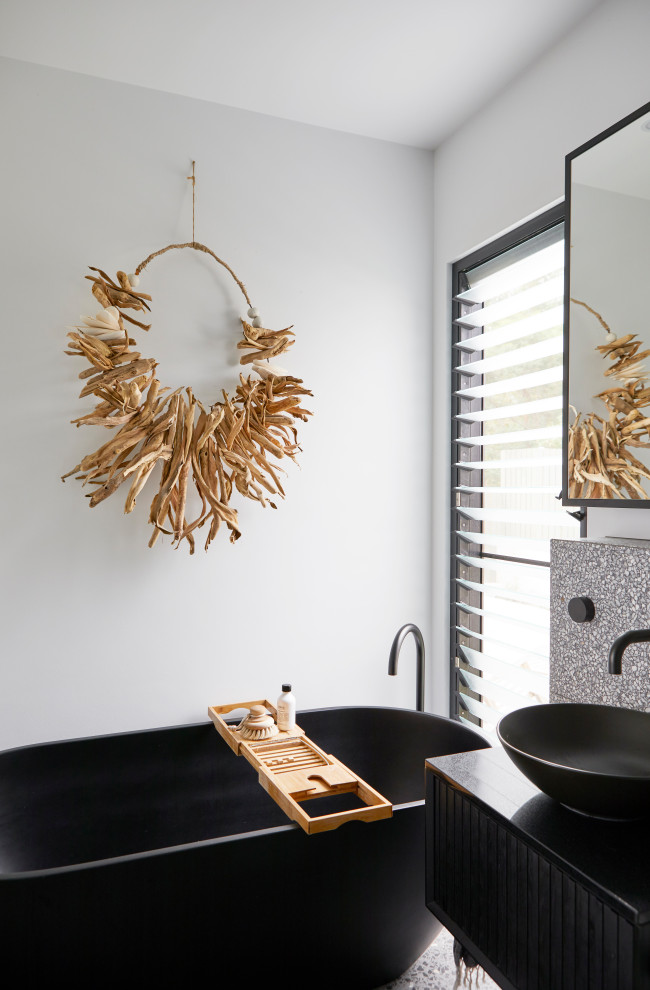 Example of a small trendy master ceramic tile and gray tile concrete floor, single-sink and gray floor freestanding bathtub design in Other with black cabinets, white walls, a vessel sink, solid surface countertops, white countertops and a floating vanity