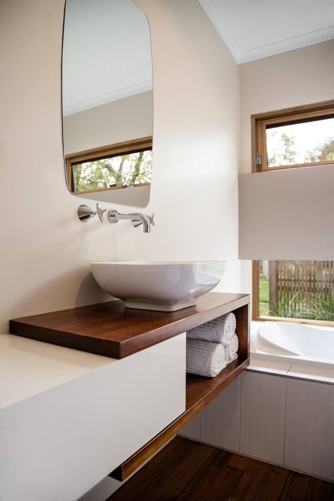 Contemporary bathroom in Melbourne with a vessel sink, wooden worktops, flat-panel cabinets, a built-in bath and dark hardwood flooring.