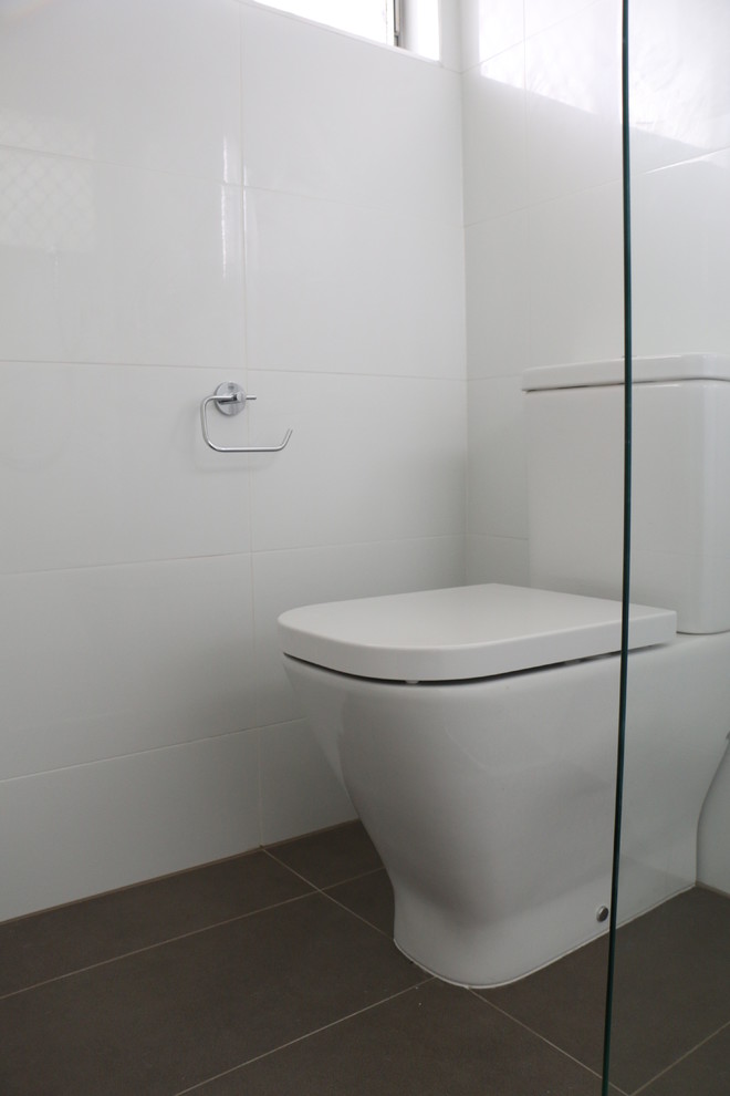 Kleines Modernes Badezimmer mit Eckdusche, weißen Fliesen, Porzellanfliesen, weißer Wandfarbe, Porzellan-Bodenfliesen, Aufsatzwaschbecken, grauem Boden, Falttür-Duschabtrennung und weißer Waschtischplatte in Brisbane