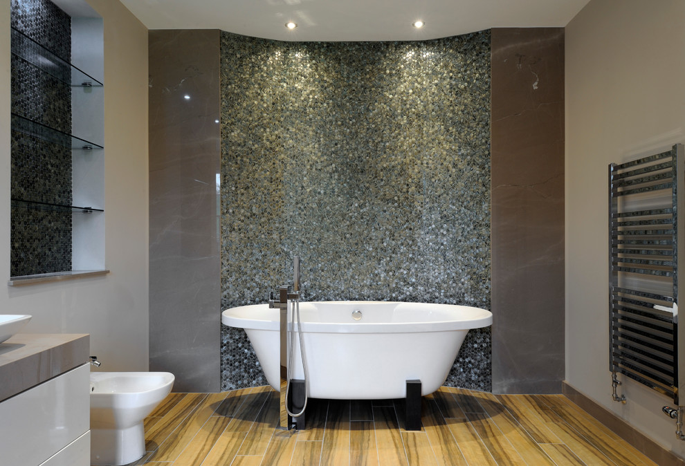 Réalisation d'une salle de bain principale design avec un placard à porte plane, des portes de placard blanches, une baignoire indépendante, un carrelage multicolore, mosaïque et un mur gris.
