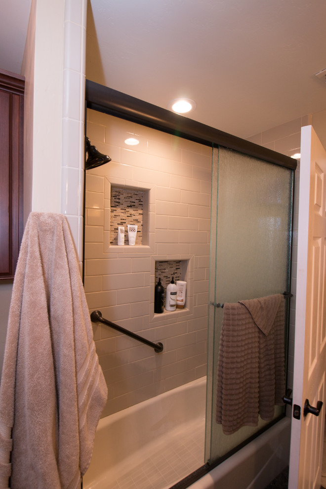 Example of a mid-sized classic kids' beige tile and subway tile porcelain tile and black floor bathroom design in Other with raised-panel cabinets, brown cabinets, a two-piece toilet, yellow walls, an undermount sink, quartz countertops and beige countertops