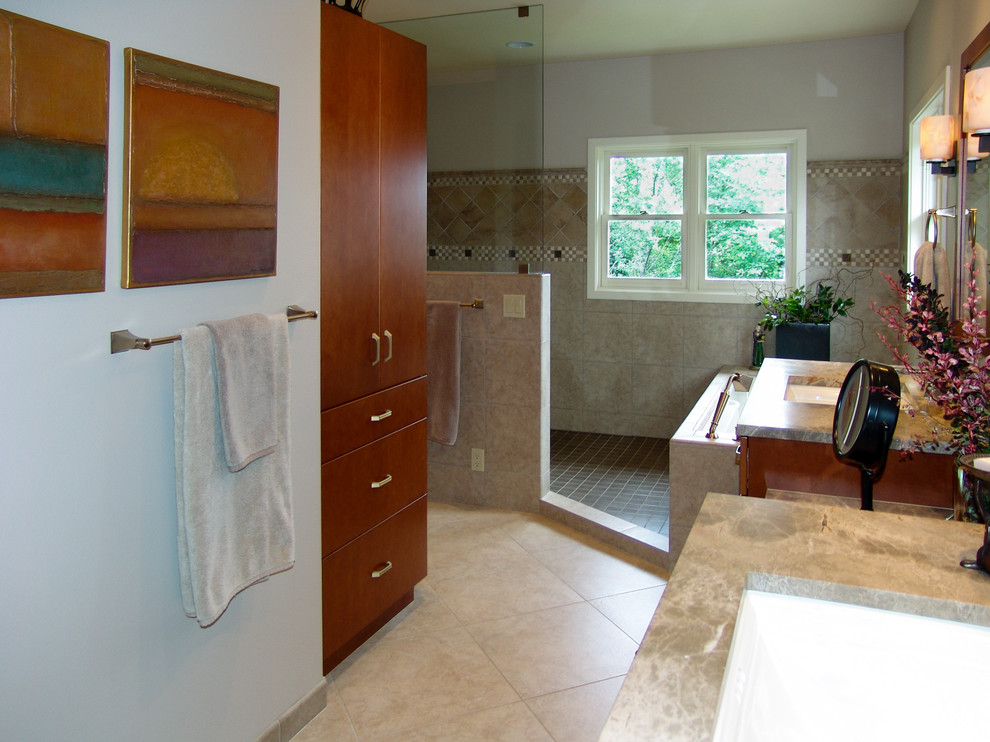 Example of a large transitional master beige tile and porcelain tile porcelain tile, brown floor and double-sink bathroom design in Seattle with an undermount sink, flat-panel cabinets, medium tone wood cabinets, marble countertops, an undermount tub, a two-piece toilet, beige walls, brown countertops and a built-in vanity