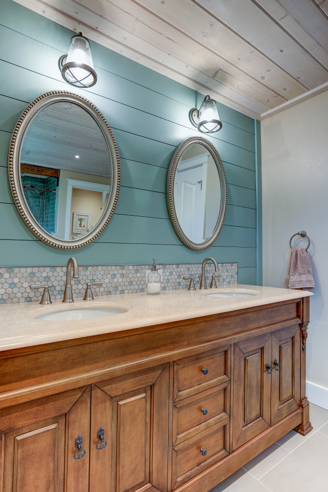 Пример оригинального дизайна: большая ванная комната в стиле кантри с ванной в нише, душем над ванной, унитазом-моноблоком, синей плиткой, керамической плиткой, бежевыми стенами, полом из керамической плитки, врезной раковиной, бежевым полом, шторкой для ванной, белой столешницей, сиденьем для душа, тумбой под две раковины, напольной тумбой, потолком из вагонки, стенами из вагонки, фасадами цвета дерева среднего тона и столешницей из гранита
