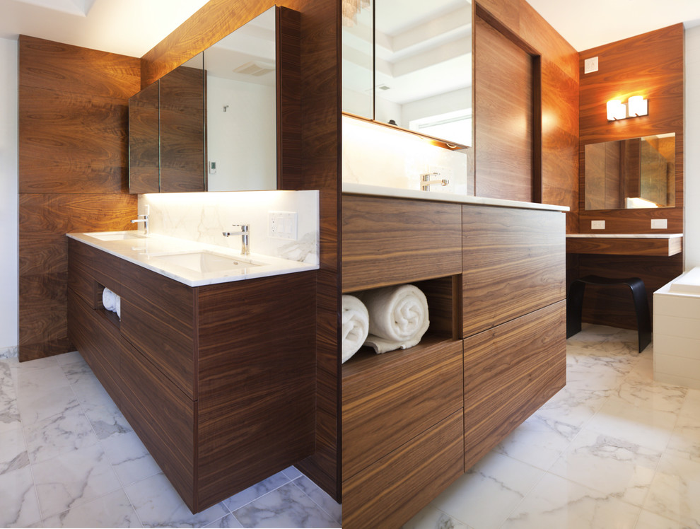 Cette image montre une salle de bain design en bois brun avec un lavabo encastré, un placard à porte plane et un carrelage blanc.