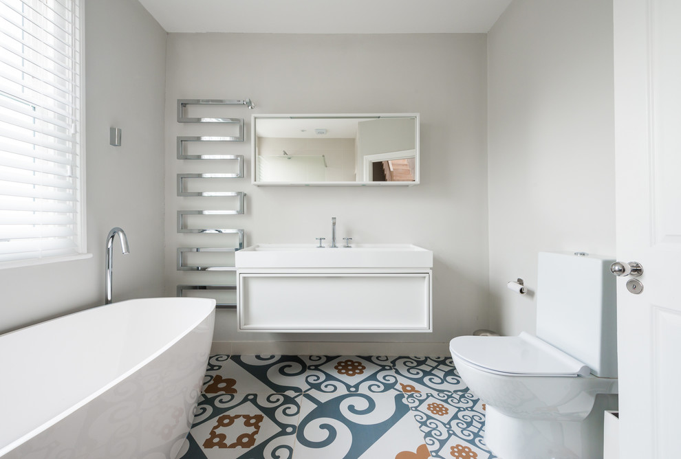 Immagine di una piccola stanza da bagno padronale boho chic con vasca freestanding, piastrelle multicolore, piastrelle in ceramica, pareti grigie, pavimento con piastrelle in ceramica e lavabo sospeso