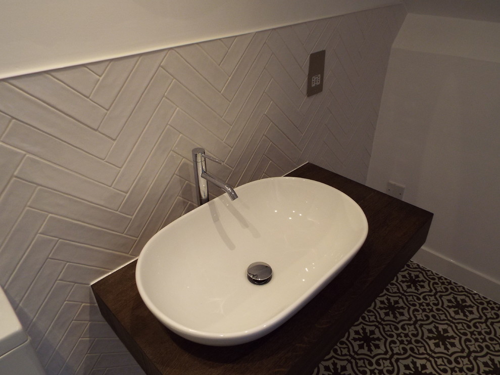 Inredning av ett shabby chic-inspirerat mellanstort brun brunt en-suite badrum, med öppna hyllor, skåp i mörkt trä, en öppen dusch, en toalettstol med separat cisternkåpa, vit kakel, keramikplattor, vita väggar, klinkergolv i keramik, ett fristående handfat, träbänkskiva, svart golv och med dusch som är öppen
