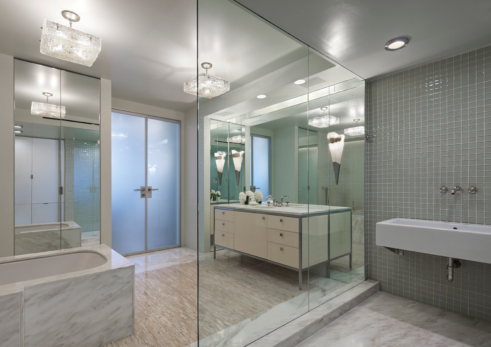 Пример оригинального дизайна: ванная комната в современном стиле с раковиной с несколькими смесителями, плоскими фасадами, бежевыми фасадами, полновстраиваемой ванной и серой плиткой