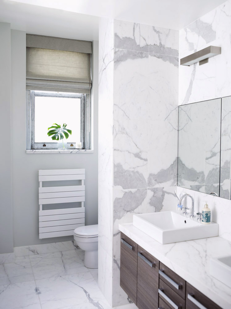 Пример оригинального дизайна: ванная комната в стиле модернизм с настольной раковиной, плоскими фасадами, темными деревянными фасадами, белой плиткой и мраморной плиткой