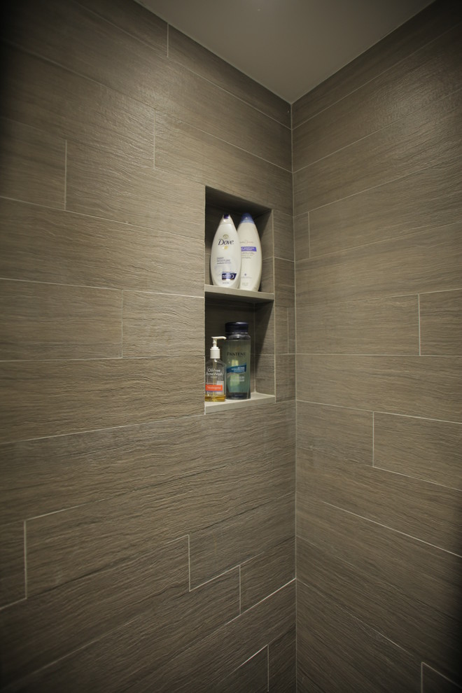 Cette image montre une salle de bain design en bois brun de taille moyenne avec un placard à porte plane, WC séparés, un carrelage gris, des carreaux de porcelaine, un mur gris, un sol en carrelage de porcelaine, un lavabo intégré et un plan de toilette en quartz modifié.