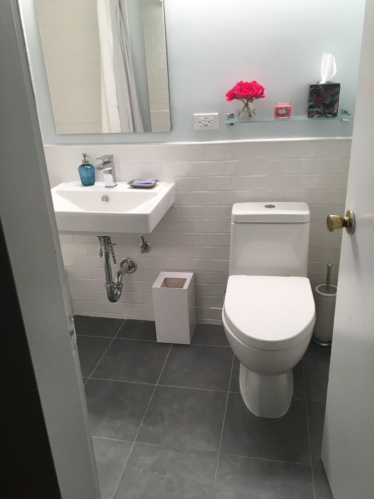 Bathroom - small contemporary white tile and ceramic tile porcelain tile and blue floor bathroom idea in New York with a one-piece toilet, blue walls and a wall-mount sink